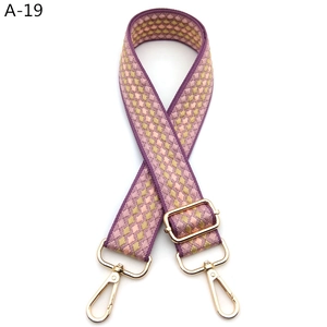 Detail view of purple geometric jacquard bag strap with gold metal lobster hooks
