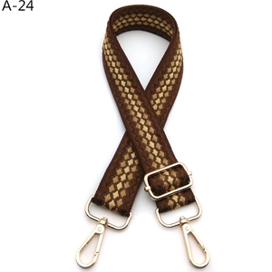 Detail of adjustable brown and gold jacquard strap with polished metal swivel hooks