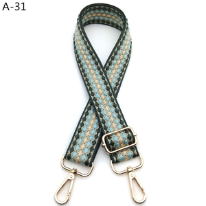 Close-up of diamond pattern woven bag strap with adjustable light gold metal hardware