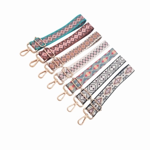 Close-up of assorted ethnic style jacquard bag straps with golden metal swivel hooks