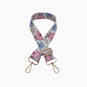Adjustable floral bag strap with pink and blue flowers and gold metal hardware