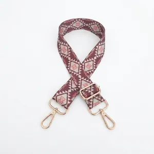 Detailed view of adjustable ethnic geometric pattern bag strap with gold metal lobster clasps