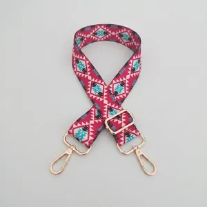 Close-up of adjustable woven shoulder strap with magenta geometric pattern and gold clips