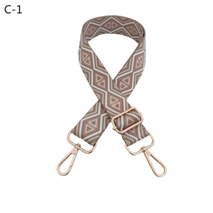 Detailed view of adjustable pink geometric diamond pattern strap with gold metal hooks