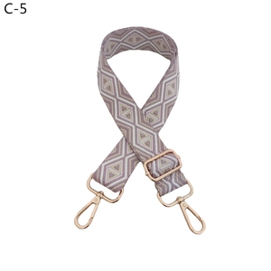 Detail of adjustable woven bag strap with purple rhombus pattern and rose gold clasps