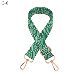 Detail of adjustable woven bag strap with green rhombus pattern and gold lobster clasps