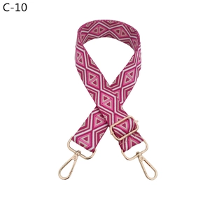 Detail of pink geometric pattern polyester strap with golden alloy hardware and swivel hooks