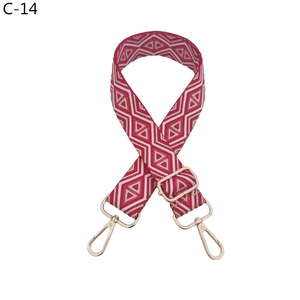 Detail of red and white geometric woven strap with shiny gold lobster claw clasps