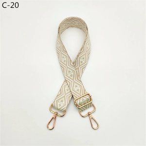 Detail view of woven diamond pattern bag strap with gold metal lobster clasps
