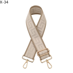 Close-up of adjustable wide bag strap with khaki geometric pattern and gold hardware
