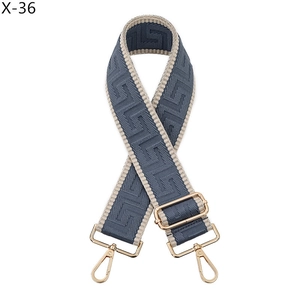 Detail of adjustable blue geometric pattern bag strap with light gold lobster clasps
