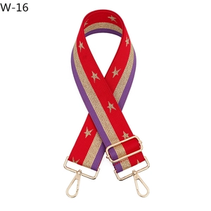 Detail of adjustable woven bag strap featuring gold stars and red purple striped pattern