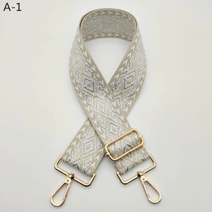 Detail view of the wide jacquard bag strap featuring a beige geometric diamond pattern