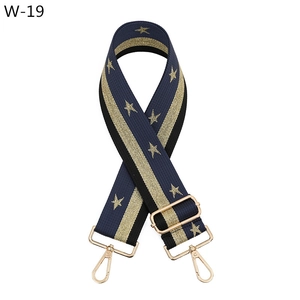 Detail of navy woven bag strap with golden star patterns and adjustable metal buckle