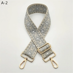 Detail view of jacquard geometric replacement strap with gold metal swivel hooks and buckles