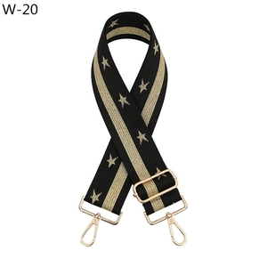 Close-up of black bag strap with gold star embroidery and metal swivel hooks