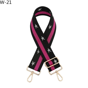 Detail of thickened black and pink woven strap with silver stars and gold metal buckles
