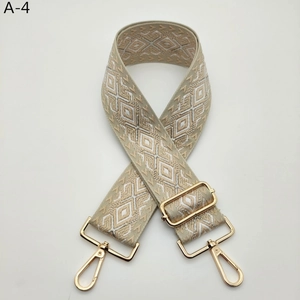 Macro view of adjustable jacquard bag strap with golden hardware and rhombus patterns