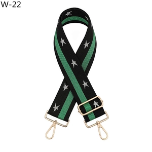 Detail of wide woven strap with green stripes, silver stars, and golden metal clips