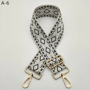Detail of jacquard wide shoulder strap with black diamond pattern and gold metal hooks