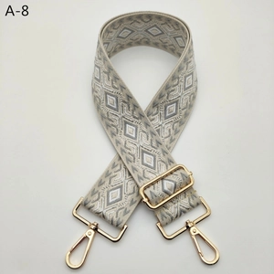 Detail of adjustable geometric jacquard shoulder strap with gold metal swiveling hooks