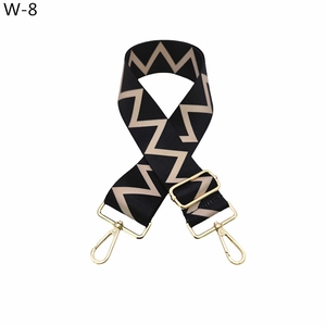 Detail of wide adjustable shoulder strap with black beige chevron pattern and gold clips