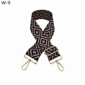 Detail of adjustable bag strap with gold metal buckles and brown geometric pattern