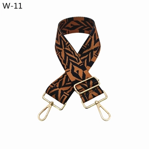 Close-up of adjustable fabric bag strap with brown tribal pattern and gold metal hardware