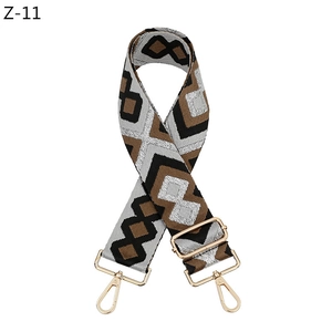 Detailaufnahme des verstellbaren Taschenriemens mit geometrischem Muster und Gold-Hardware