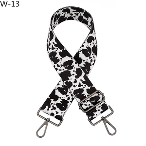 Close-up of cow print replacement bag strap with gunmetal lobster clasps and buckle