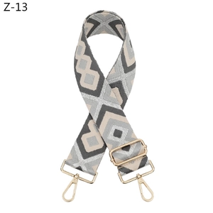 Details des verstellbaren Taschenriemens mit geometrischem Muster und goldenen Metallhaken