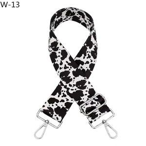 Adjustable wide replacement bag strap with black and white cow print and silver metal buckles