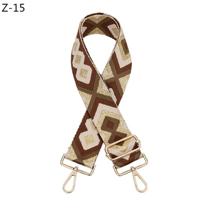 Detail eines geometrisch gewebten Taschenriemens mit goldenen Metallkarabinerhaken