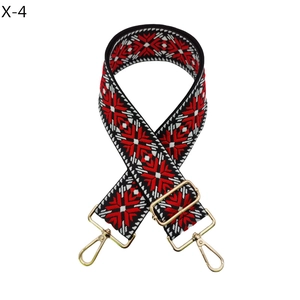 Detail of red and black ethnic embroidered bag strap with golden metal buckles