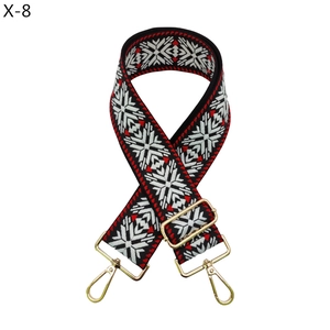 Close-up of red and black geometric ethnic woven bag strap with golden lobster clasps