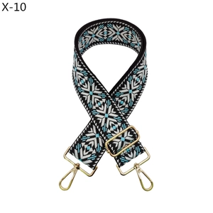 Detail of adjustable ethnic style bag strap with blue snowflake patterns and gold hardware