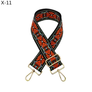 Macro detail of ethnic style woven bag strap with golden hardware and floral patterns