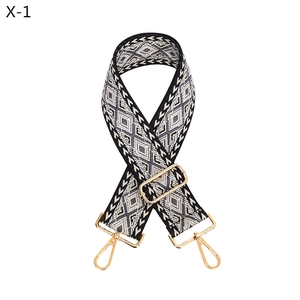 Detail of adjustable geometric jacquard guitar-style shoulder strap with gold metal hooks