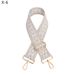 Detail of adjustable woven purse strap with geometric rhombic pattern and gold buckles