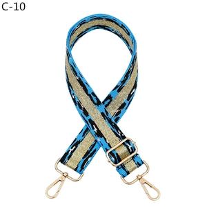 Détail d'une bandoulière bleue réglable motif tigre avec mousquetons dorés