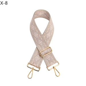 Detail of adjustable rhombus jacquard wide shoulder strap with gold metal lobster clasps