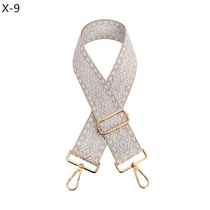 Close-up of geometric jacquard bag strap with silver diamond patterns and gold hooks