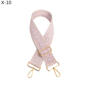 Detail of pink and purple geometric jacquard adjustable purse strap with gold metal hooks