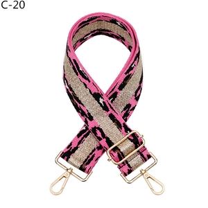 Macro shot of wide leopard print bag strap with pink webbing and golden metal buckles
