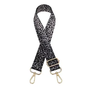 Close-up of adjustable leopard print bag strap with polished gold metal hardware buckles