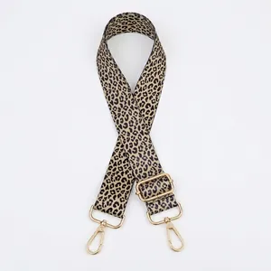 Macro shot of adjustable leopard print bag strap with polished gold metal hardware