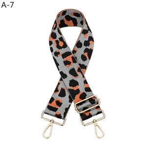 Detailed view of leopard print wide strap with gold lobster clasps for crossbody bags