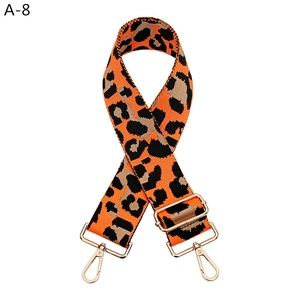 Detail of leopard print wide replacement bag strap with polished gold-tone hardware buckles