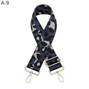 Macro detail of adjustable leopard print bag strap with polished gold-tone metal hardware