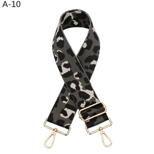 Detail of wide leopard print canvas bag strap with polished gold-tone metal hooks